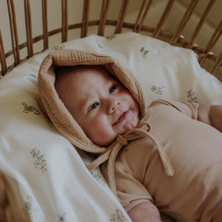 Baby laying in crib on top of the Fleur and Stripe Crib Sheet in Multi Color