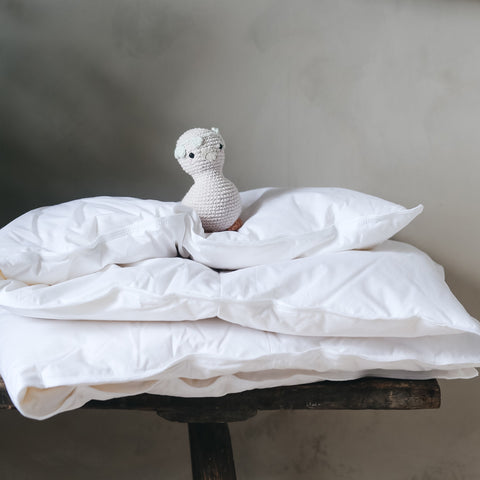 Toddler Down Duvet Insert Folded, with a stuffed toy gooseling laid on top