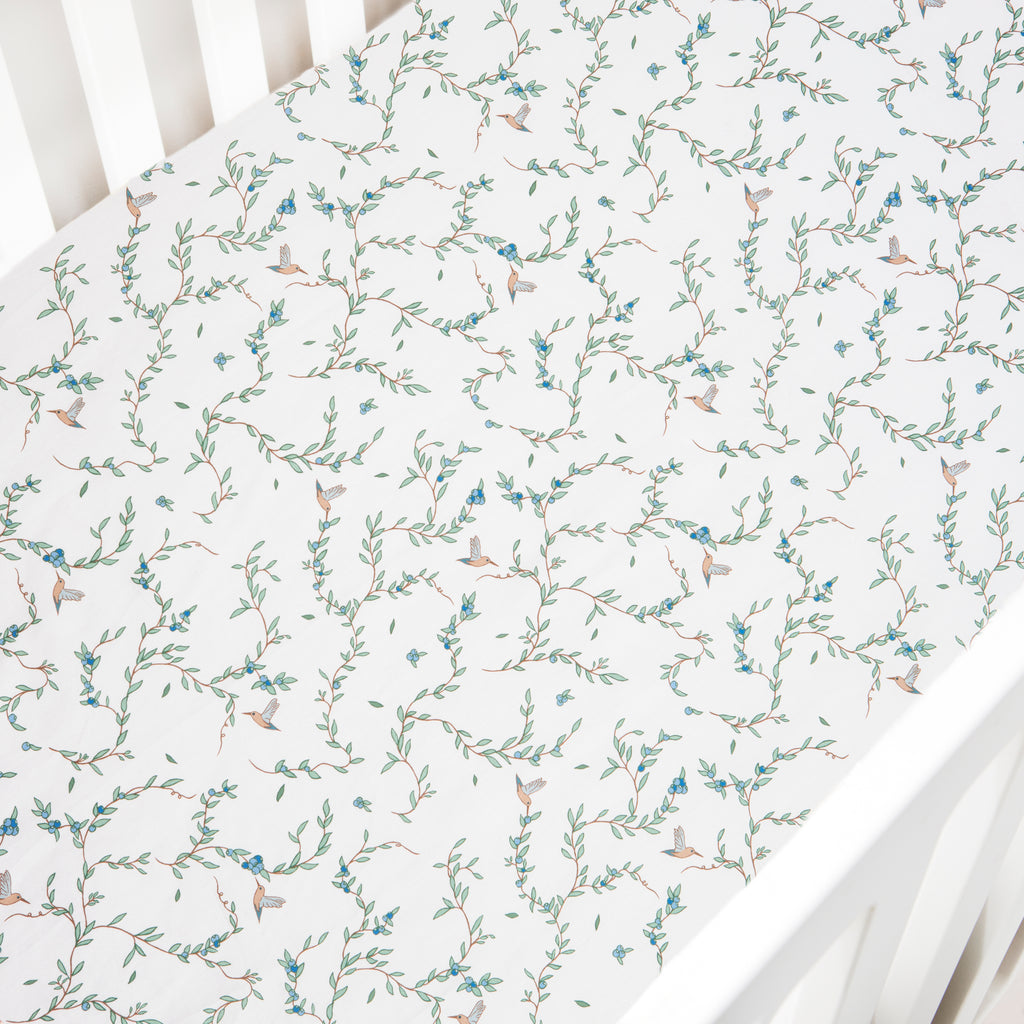 Crib Sheet in the "Secret Garden" print in the color ivory featured in a crib
