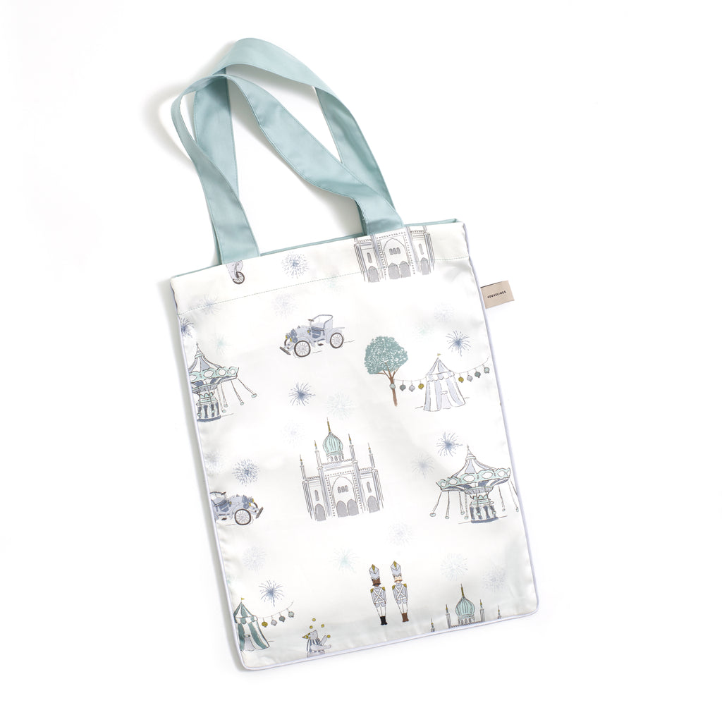 Printed tote bag is included with crib sheet in "Adventures in Wonderland" print in the color aqua