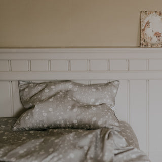 Toddler pillow in "Bird's Song" print in color grey on a bed