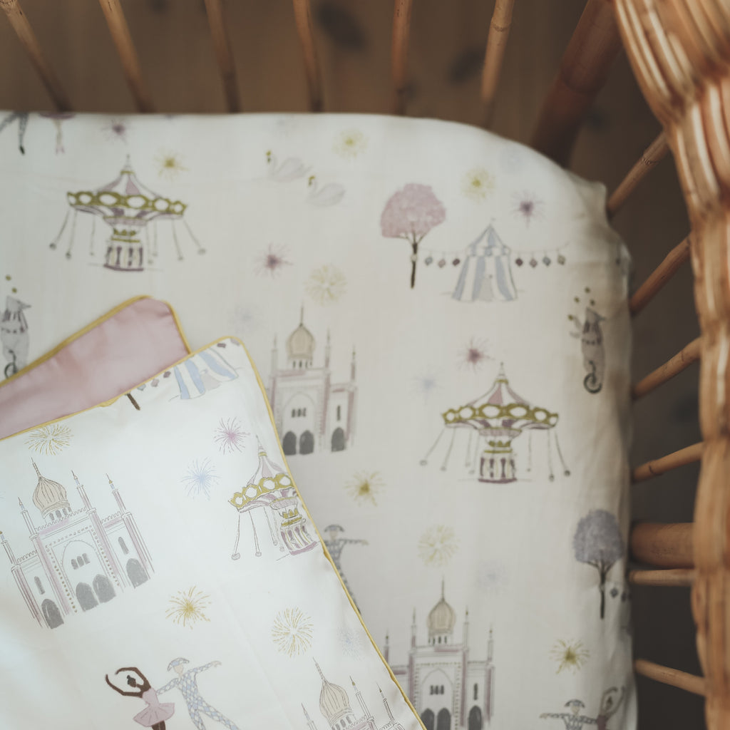 "Adventures in Wonderland" print in the color rose featured in a crib
