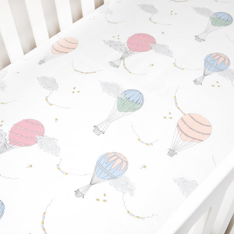 Crib Sheet in "Touch The Sky" print in the color pink featured in a crib