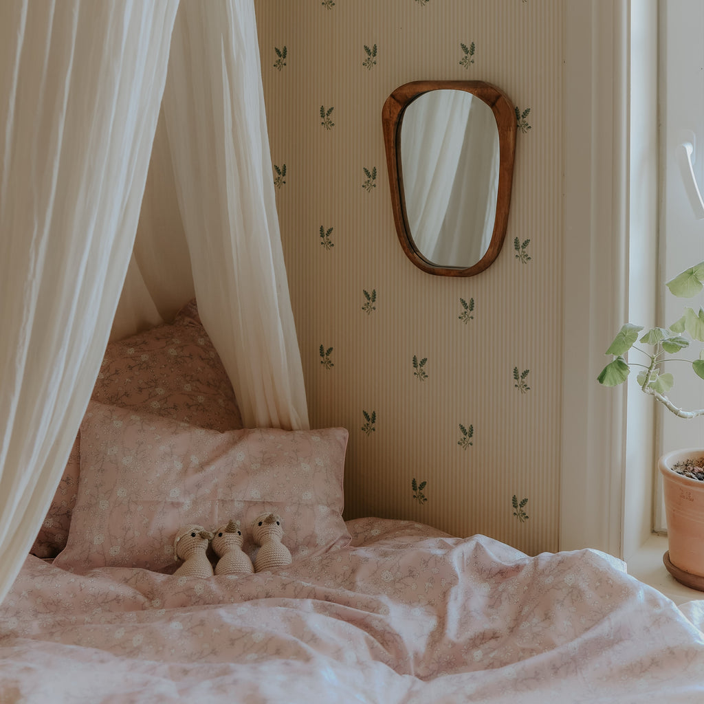 Toddler Duvet of Bird's Song Pink with Gooselings Stuffed animals laid on a bed, with a canopy over them