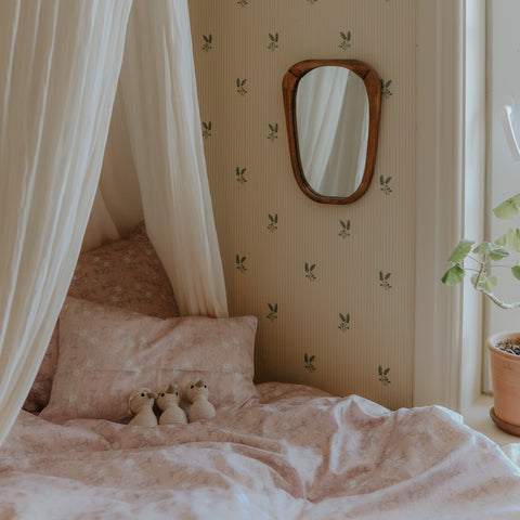 Toddler Duvet of Bird's Song Pink with Gooselings Stuffed animals laid on a bed, with a canopy over them