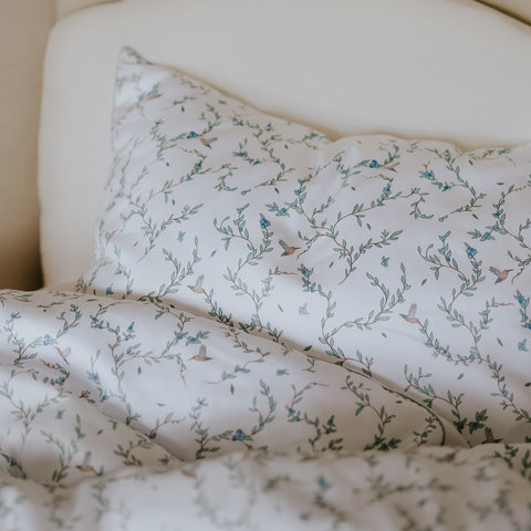 Toddler Duvet and Toddler Pillow in a bed in the "Secret Garden" print in Ivory