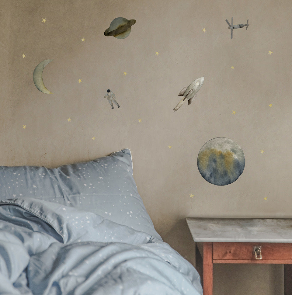 Space wall decals made up of stars, planets, rocket ships, moons, on laid out on a wall