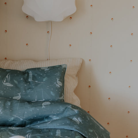 never stop exploring toddler pillow in green on a bed