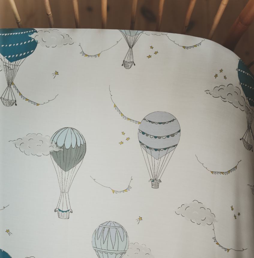 Crib Sheet in "Touch The Sky" print in the color blue featured in a crib