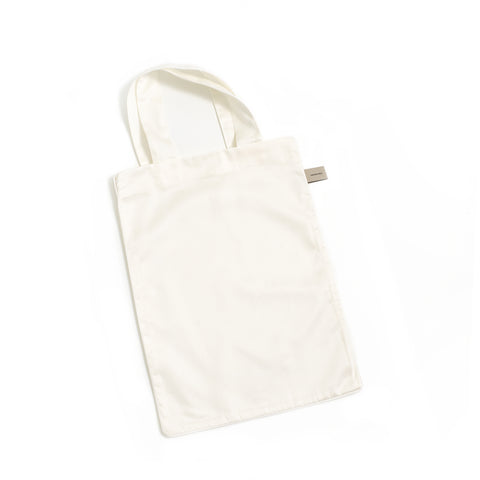 Solid tote bag is included with crib sheet in the color ivory