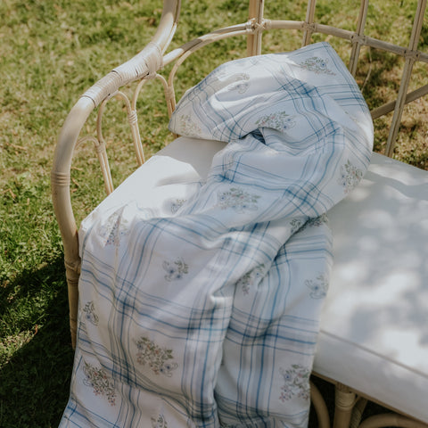 Baby Duvet laid across a bench outside in the Fleur and Stripe Print in Multi Color